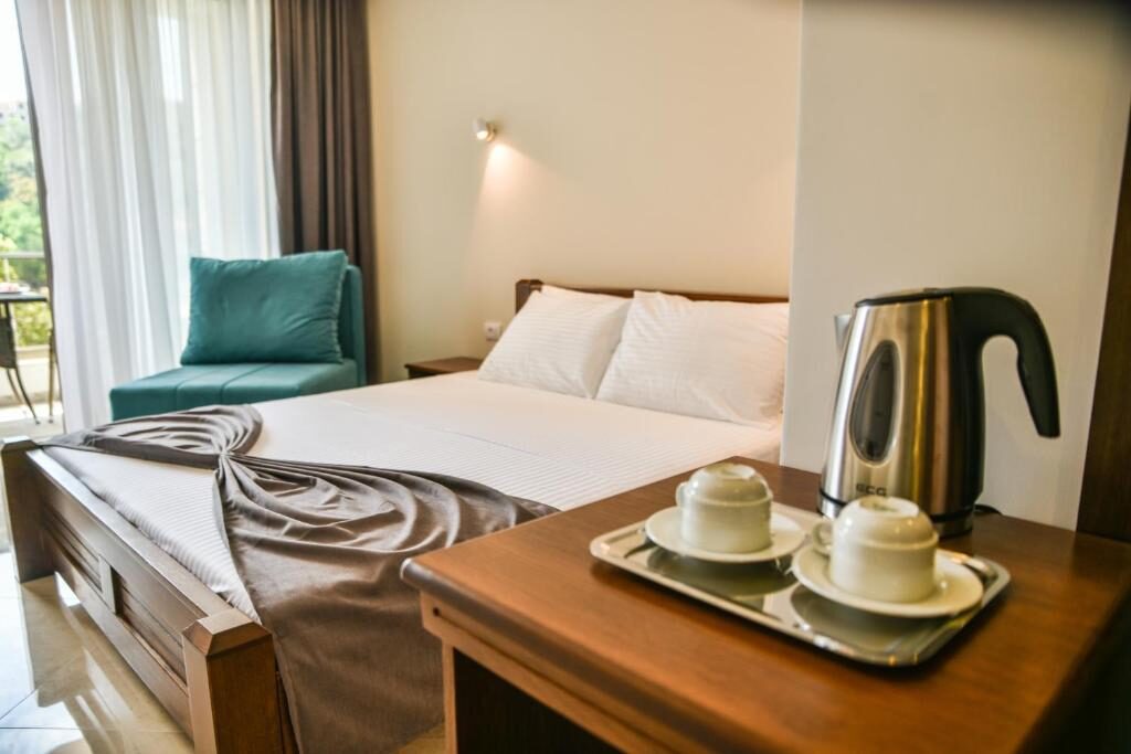 Double room at Hotel Prova with a made bed and tea tray